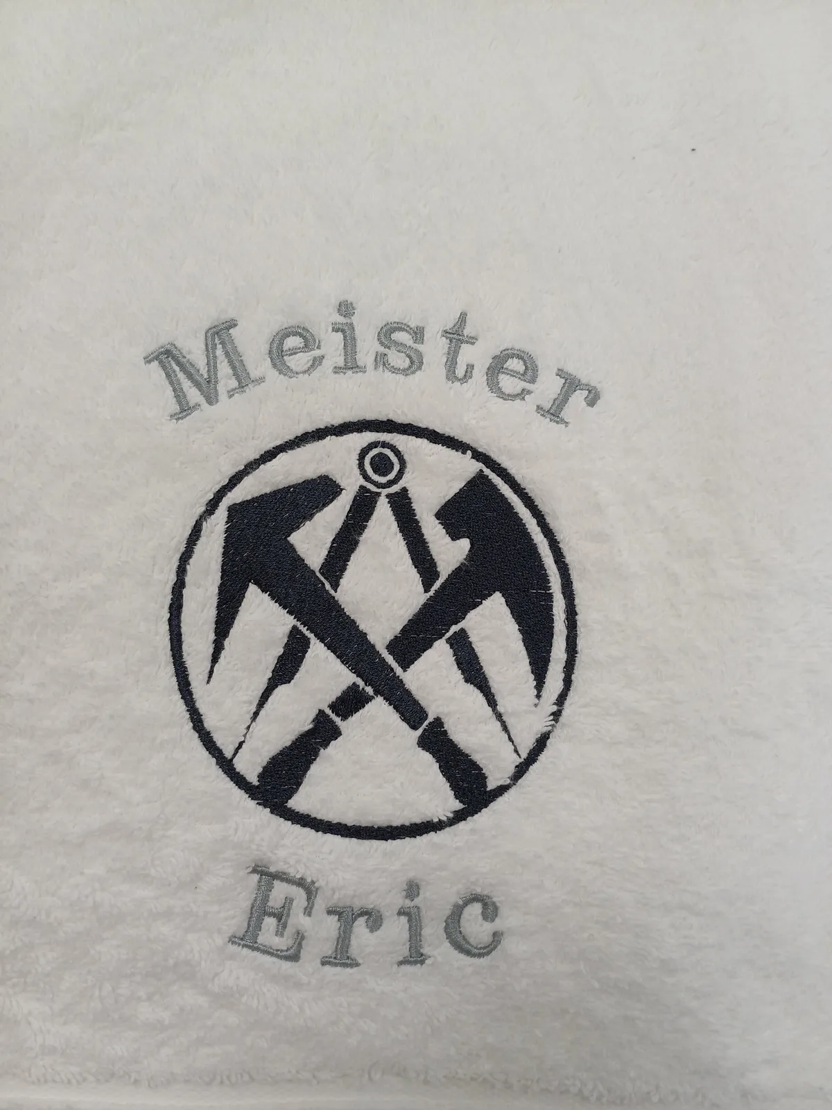 Personalisierter Name mit Handwerker-Emblem, gestickt auf ein Handtuch